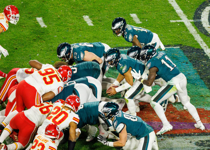 Philadelphia Eagles quarterback Jalen Hurts bends over with the ball preparing to be pushed